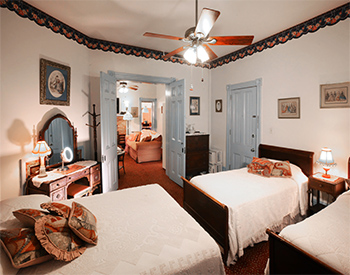 Bedroom with three beds, blue doors, and entry to living room
