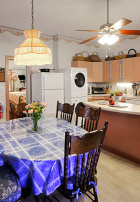Large full kitchen with dining room table with blue tablecloth and en suite washer and dryer
