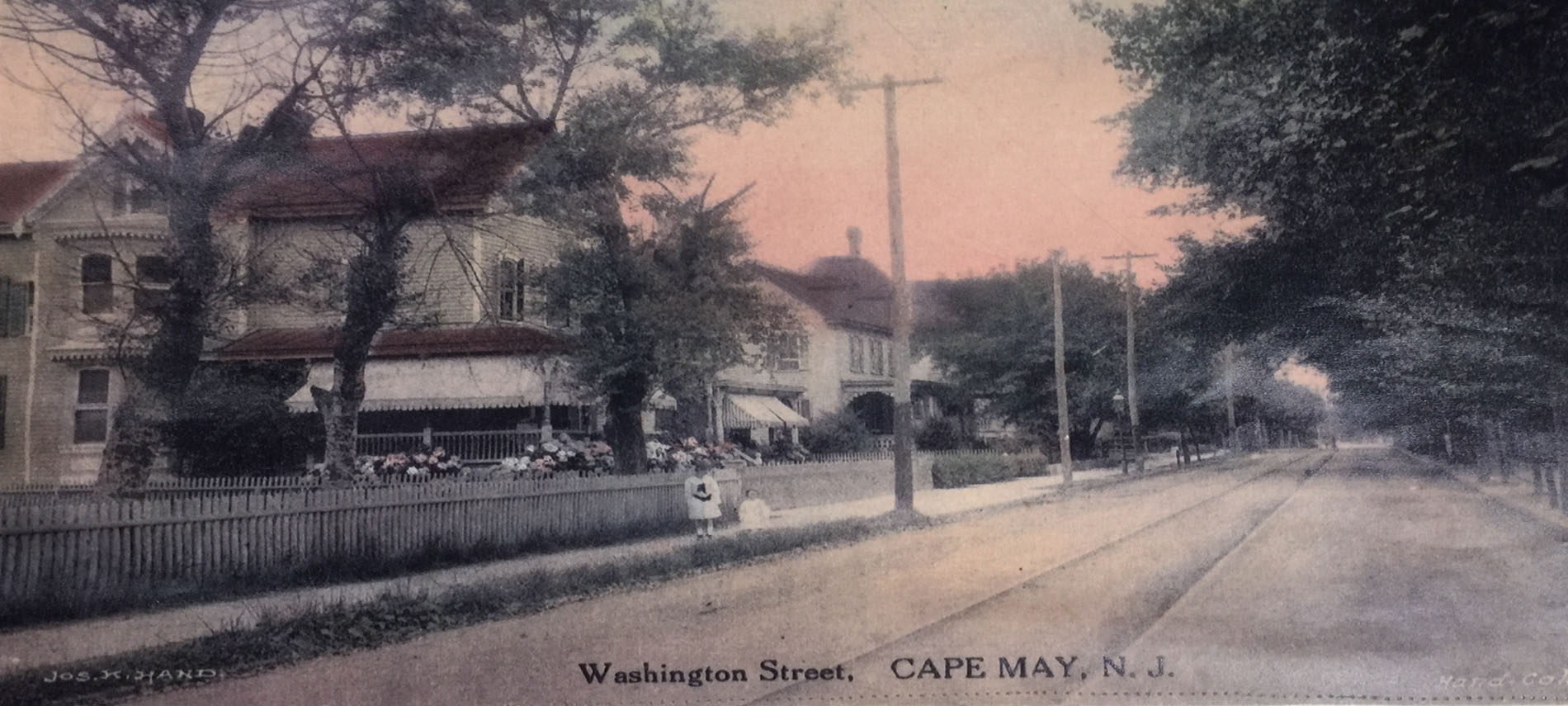 Watercolor postcard of the white and red guest house with a pink and white sunset