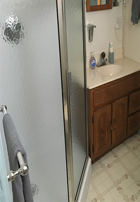 Light blue wall in bathroom with brown and beige sink.